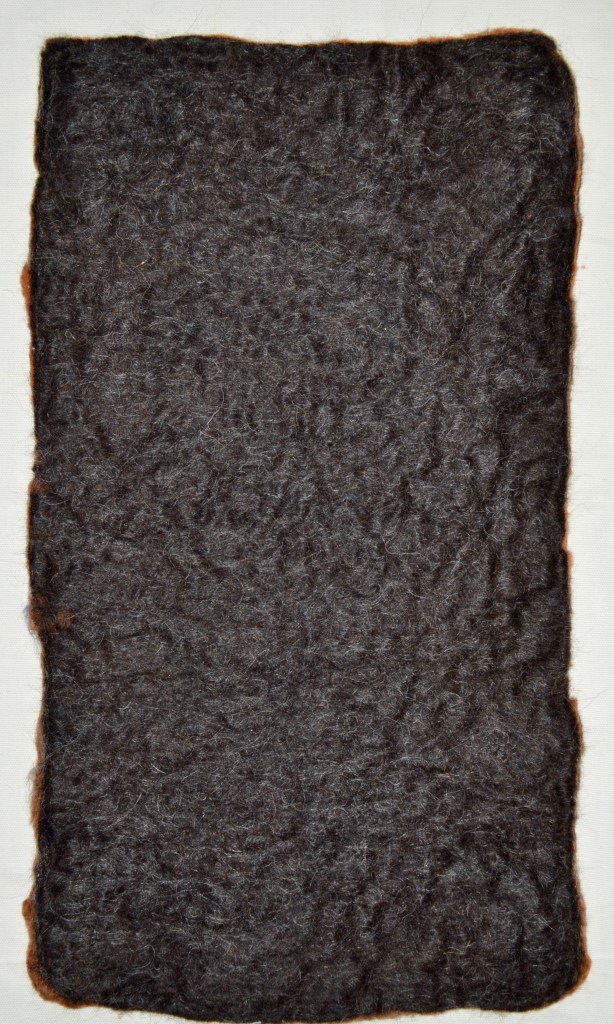 Backside of a Minimalist felt composition in earthy red-browns, featuring floating off-white wool forms and ghostly textures — a quiet, atmospheric piece with bodily and natural echoes.