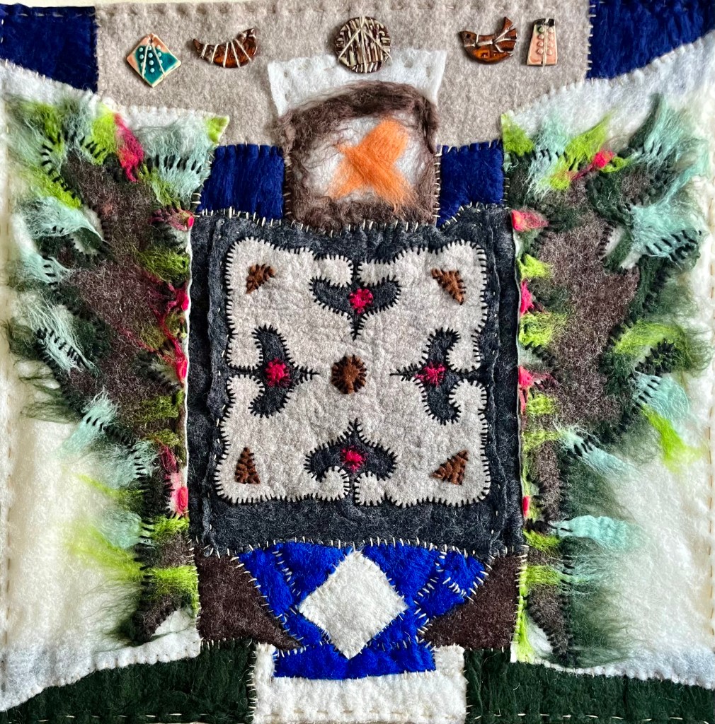 Large felt collage with Persian carpet-inspired center, soft green wings, and ceramic elements, merging traditional patterns with symbolic forms of protection and flight.